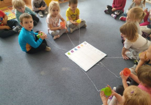 Dzieci trzymają w rękach kubeczki na sznurku, aby porozmawiać ze sobą. (8 zadanie z akcji Code Week)